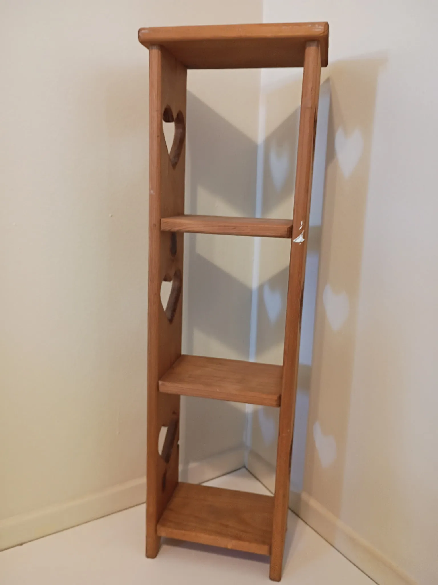 Bookshelf before refinishing: bare wood with heart cutouts