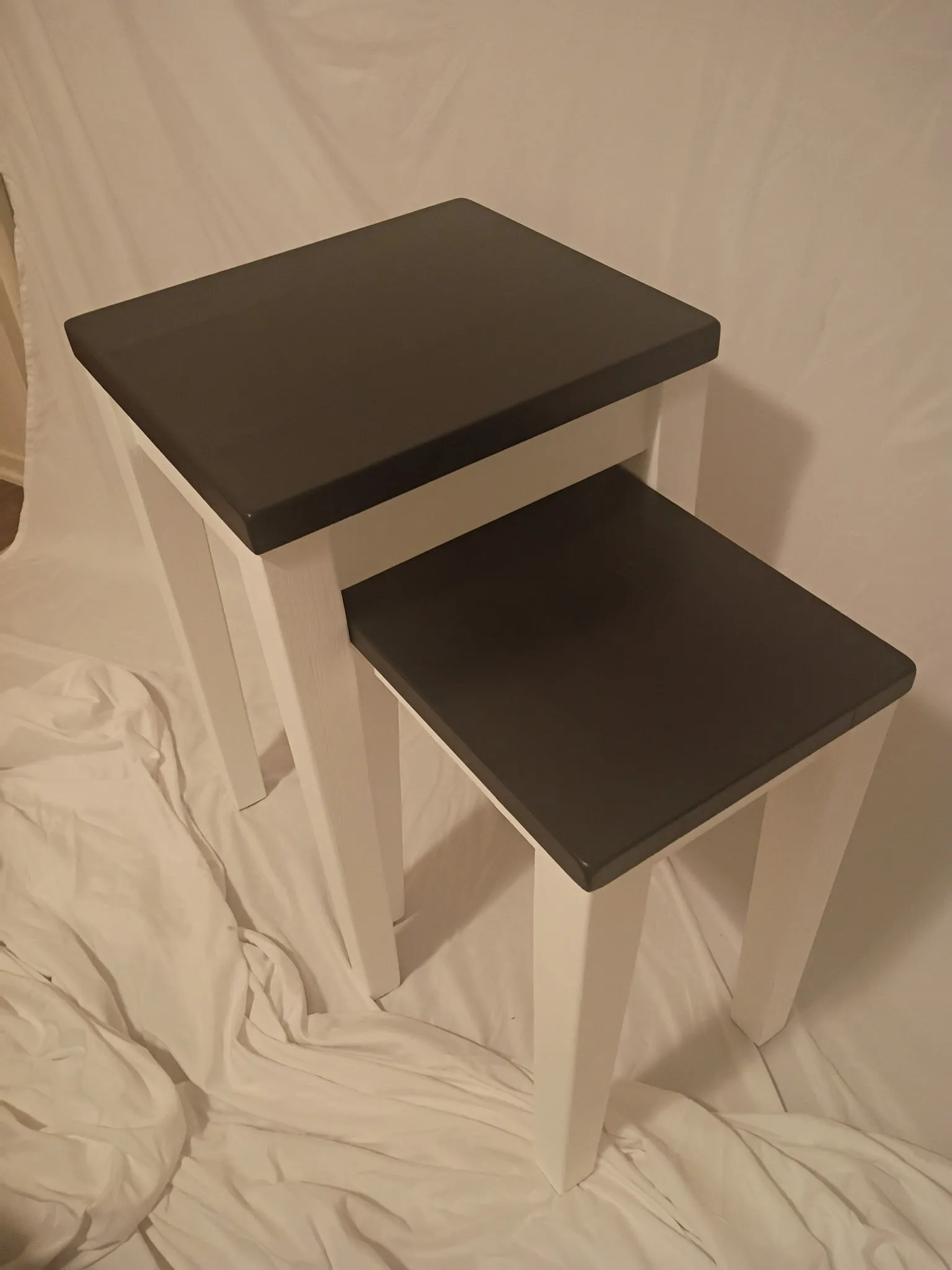Nesting tables after refinishing: crisp white legs with black tabletops