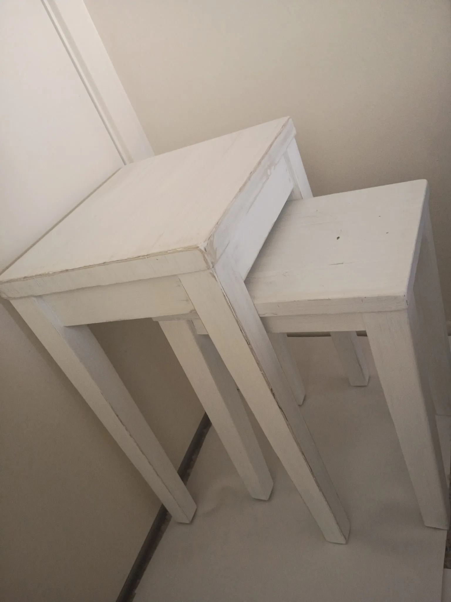 Nesting tables before refinishing: worn, chipped white paint